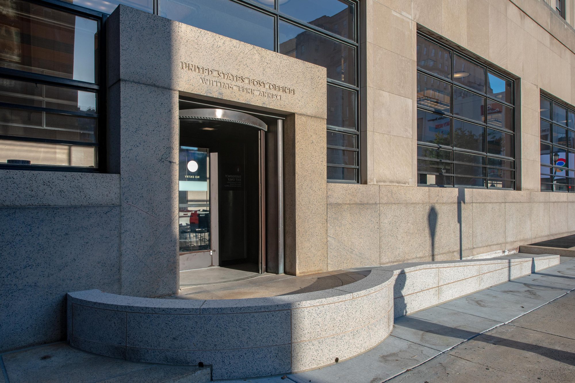 Restored bronze revolving door enclosure with new granite ramp